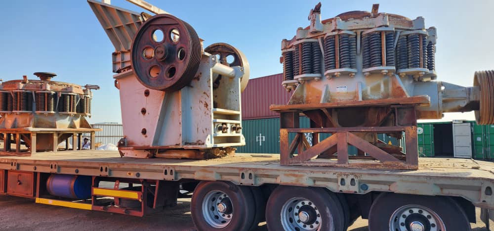 Jaw crusher and two cone crushers loaded on a flatbed trailer ready for transport to site