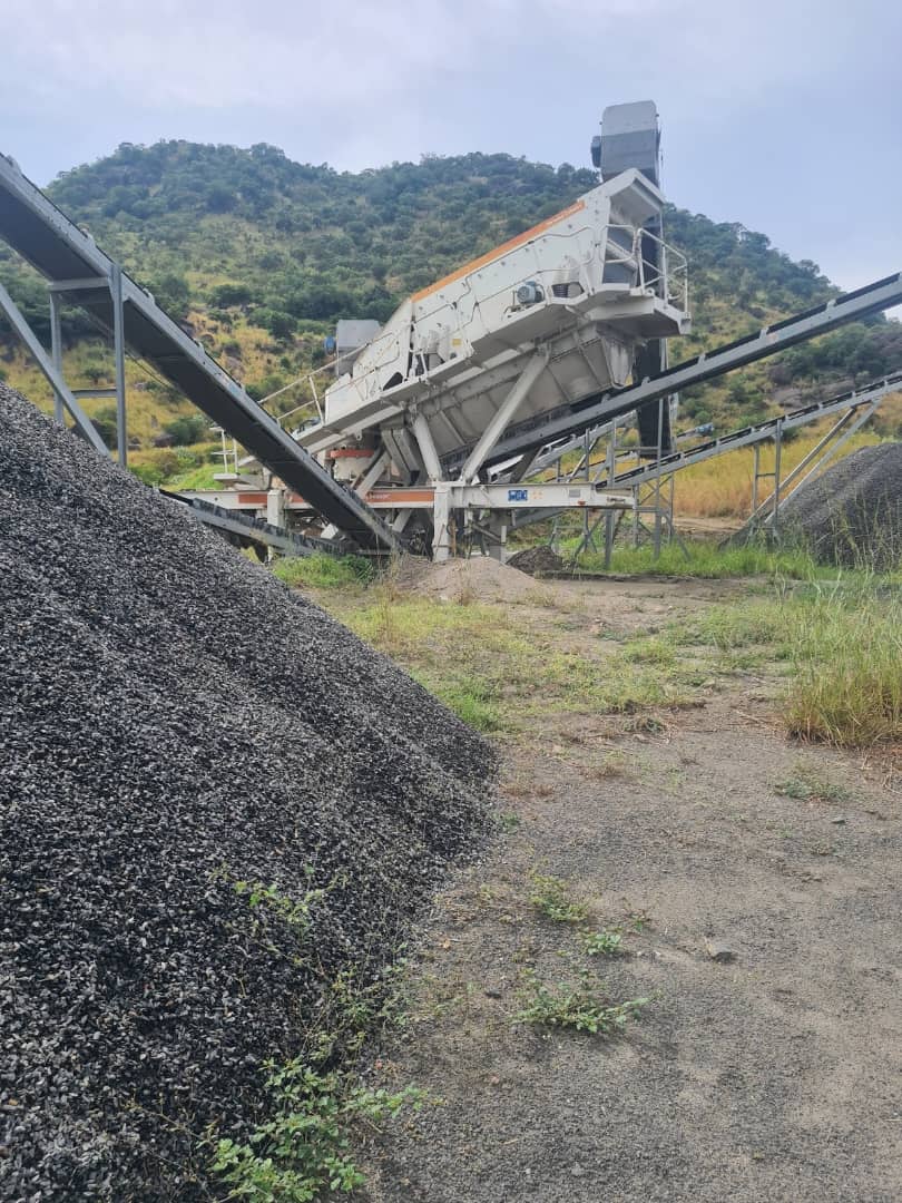 Mobile screening plant with conveyors and stockpiles of crushed aggregate on a mining site